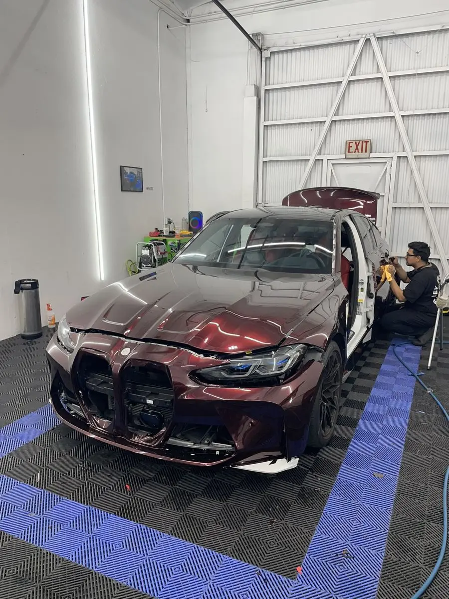 The GhostlyAuto owner installing film on a BMW M3 in the shop